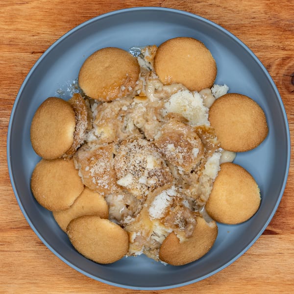 Fat Man's BBQ banana pudding dessert with vanilla wafers on a blue plate.